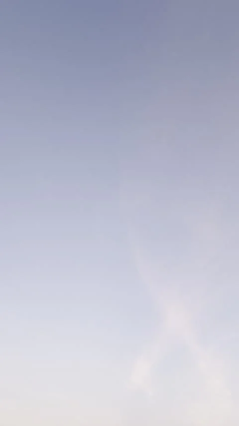Distant Airplane Crossing Pastel Sky With Wispy Clouds Video stock 344717278