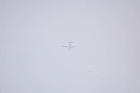 Distant Airplane Silhouette In Soft Cloudy Sky Minimal Background Stock Photos