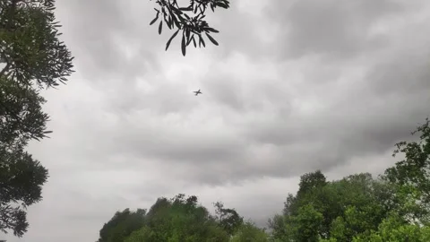A distant airplane soars high above the coastal Stock Footage 302946429