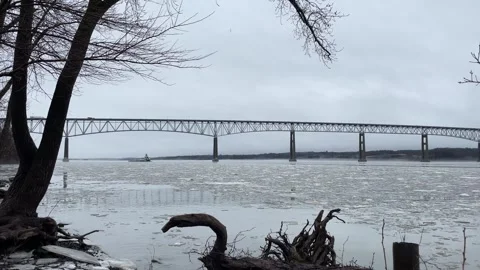 Distant Barge Passing Under Bridge with Driftwood in Foreground Stock Footage 265110622