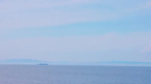 Distant cargo ship navigating the calm ocean horizon in Oita, Japan Vídeos de archivo 337073149