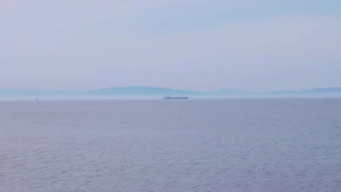 Distant cargo ship navigating the calm ocean horizon in Oita, Japan Vídeos de archivo 337073163