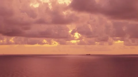 Distant Cargo Ship on Ocean Horizon Under Dramatic Pink Dusk Clouds Stock Footage 344808827