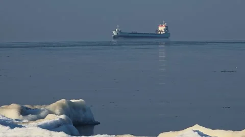 Distant Cargo Ship Over Frozen Sea in Winter Haze Stock Footage 327869084