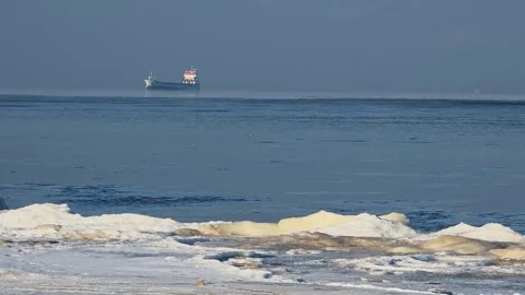 Distant Cargo Ship Over Frozen Sea in Winter Haze Stock Footage 327869090