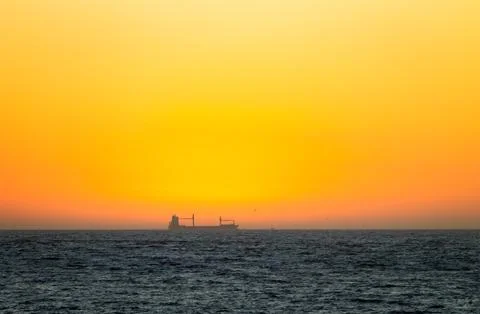 Distant Cargo Ship at Sunset Stock Photos