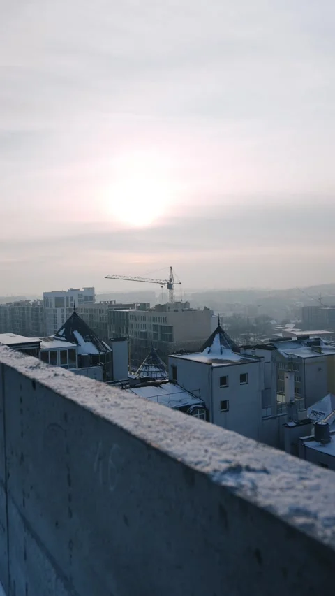 Distant city view with a crane and snow-covered rooftops Stock Footage 327842422