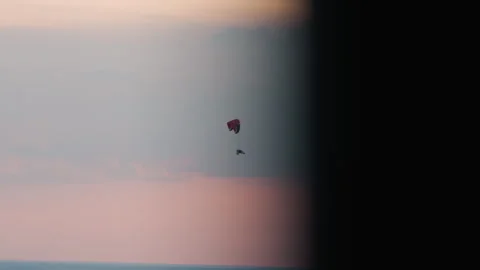 Distant colorful paraglider soaring over pastel sky at sunset Stock Footage 317148834