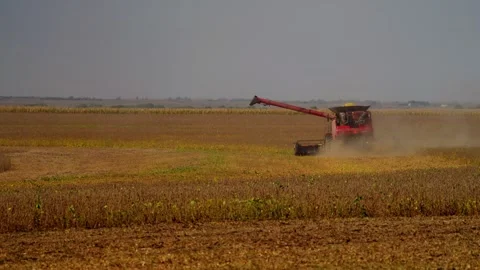 Distant combine and tractor at work in a harvested field Stock Footage 345530591