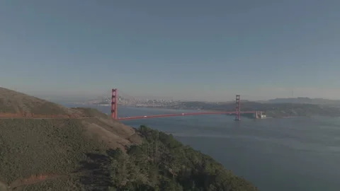 Distant drone approaching San Francisco bridge from behind hill Vídeos de archivo 336792352