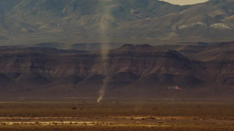 Distant dust devil tears through the desert as it reaches towering heights. Stock Footage 270498845