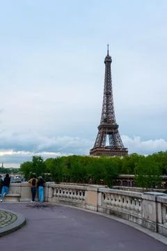 Distant Eiffel Tower view behind green trees Fotos de archivo