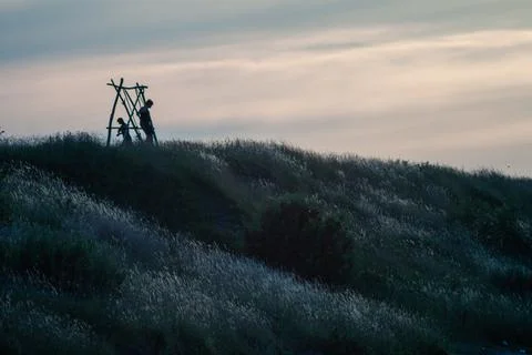 Distant figure on hill at sunset Stock Photos
