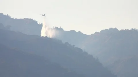 Distant Firefighting Helicopter Water Drop on Forest Fire 動画素材 117892441