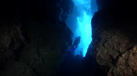 Distant group of scuba divers swimming in cavern in Solomon Islands, HD, UP27723 Stock Footage 62219089