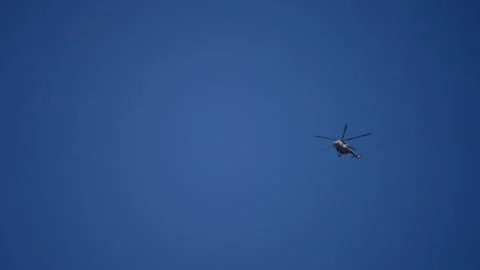 Distant helicopter hovering in a serene blue sky, travel and advanced technology Stock Footage 265491410
