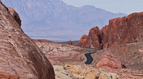 A distant highway shot through red rock wilderness at Valley of Fire State Park Stock Footage 35238656
