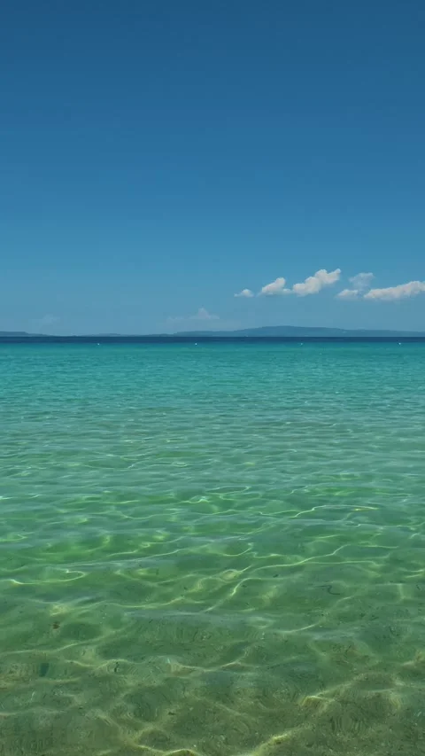 Distant hills hug the horizon, soft and serene. Trani Ammouda, Greece. Vertical Stock Footage 338357906