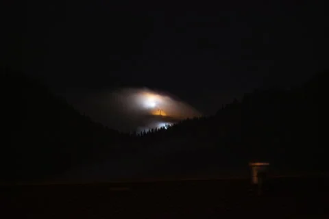 Distant illuminated ski slope covered by fog and clouds Stock Footage 260532827