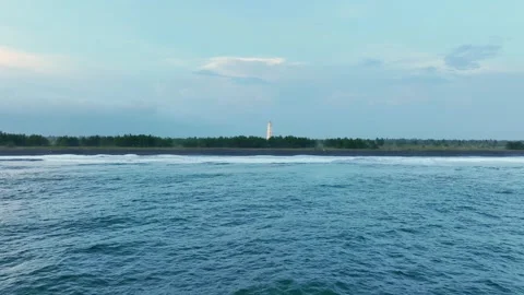 Distant lighthouse across calm coastal water Vídeo Stock 335440562