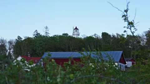 Distant Lighthouse Over Farm Landscape After Sunset – Moody Rural Scene Vidéo 310516623