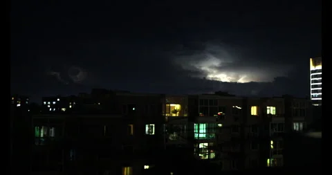 A distant lightning at night in the middle of City Stock Footage 295010059