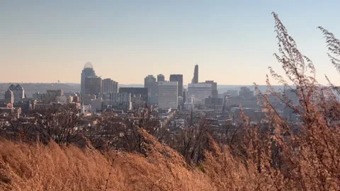 Distant midwestern city seen from on top of a grassy hill Stock Footage 256950722