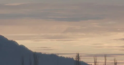 DISTANT MIGRATING BIRDS - FLYING INTO ORANGE SKY - MOUNTAINS Stock Footage 165621629