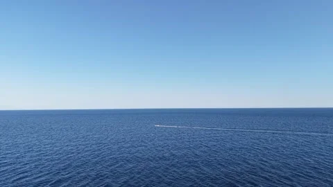 Distant Motorized Vessel Leaving Wake Across Open Sea Stock Footage 340509349