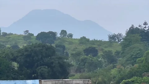 Distant mountain landscape view with lush green hills and overcast sky Stock Footage 341897308