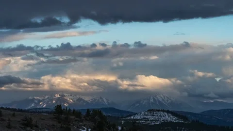 Distant mountain peaks and clouds lit by sunset. Absaroka Mountains Stock Footage 167070418
