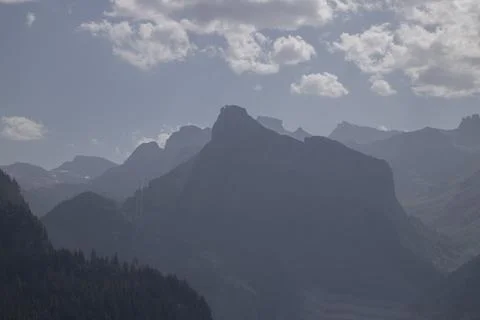 Distant mountain peaks appearing hazy under cloudy sky Stock Photos