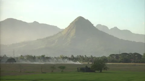 Distant mountains behind a green field Stock Footage 241352772