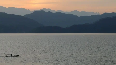 Distant Mountains, Lake And Boat Passing By In The Evening Stock Footage 86844471