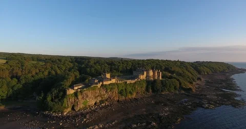 Distant Moving in Shot of a Scottish Castle within a Green Leafy Forest Stock Footage 97380475