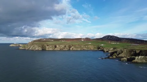 Distant overcast South stack lighthouse aerial view rocky cliff shore of Stock Footage 321942385