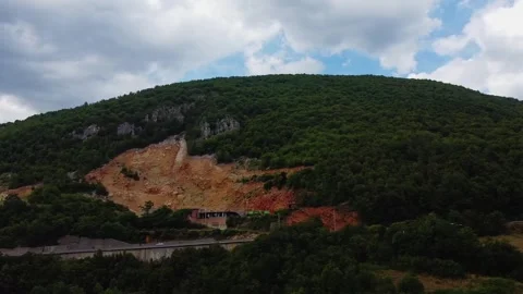 Distant Pan Shot Across Green Hillside Showing Construction Site and Active Stock Footage 320048374