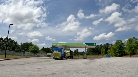 Distant Pan of Waste management trash trucks in line at a Natural Gas Stock Footage 180134502