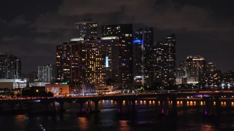 Distant panoramic view of night Miami city, Florida, from sea. MacArthur Video stock 275584898