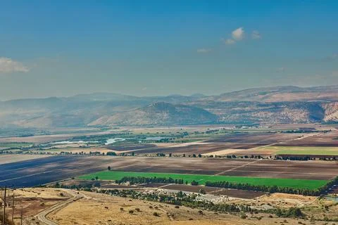 A distant panoramic view of an urban settlement with green farmland in the Foto stock
