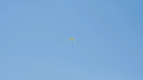 Distant paraglider soaring through a vast clear blue sky above the Carpathian Stock Footage 347579113