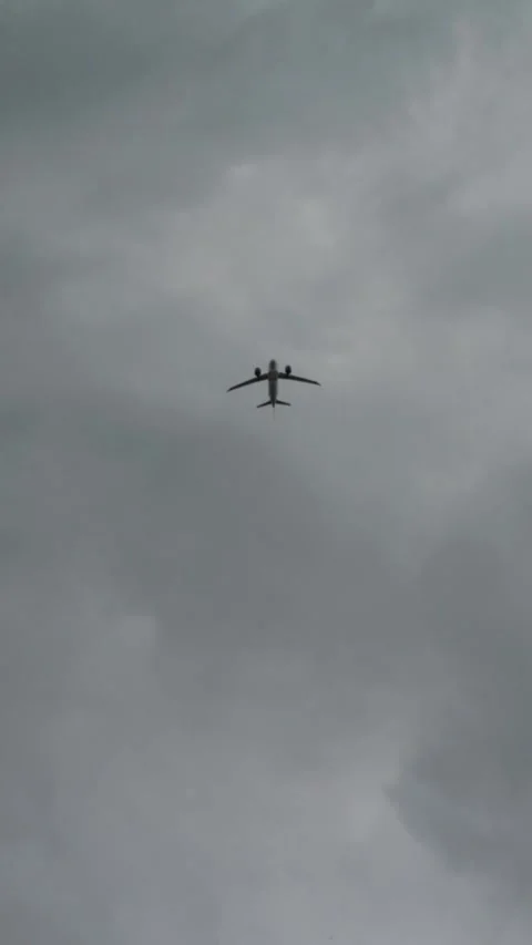 Distant passenger airplane crosses a cloudy sky from below, creating a mini.. Stock Footage 340023470