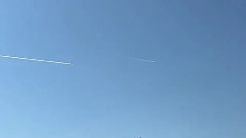 Distant passenger jet plane flying on high altitude on clear blue sky Stock Footage 251548355