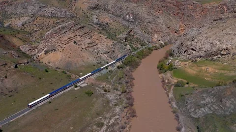 Distant passenger train moves along a riverbank (Dogu Ekspresi) Vídeo Stock 338200704