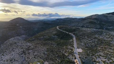 Distant peak, purple sunset clouds, blue sky, lush roadside vegetation. Видео 328999011