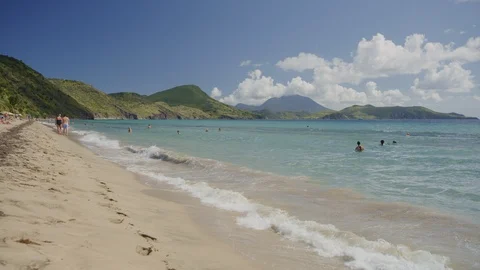 Distant people swimming in waves at ocean beach / Basseterre, St. Kitts Stock Footage 128984207