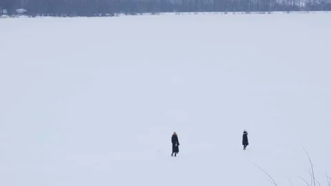 Distant people in winter coats wander on white snowy lake Stockbeeldmateriaal 155794845