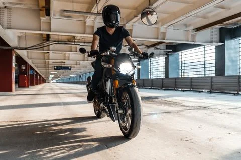 Distant plan of biker riding motorcycle at parking. Stock Photos