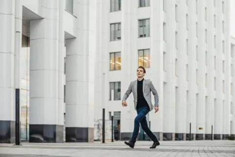 Distant plan of happy man going to or from work and dancing. Stock Photos