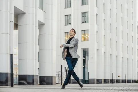Distant plan of happy man going to or from work and dancing. Stock Photos